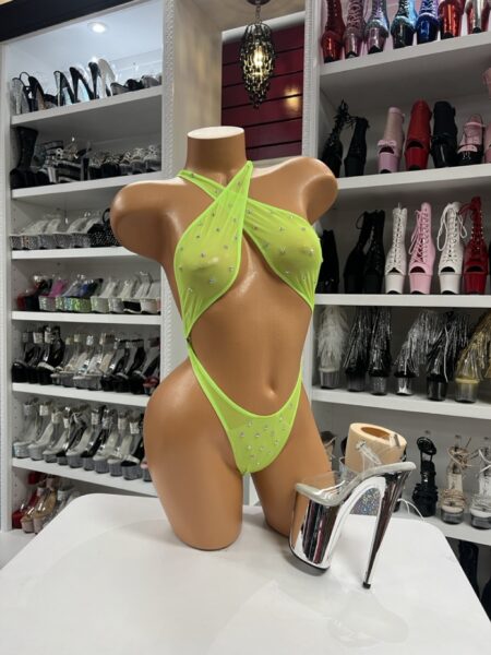 Neon green slingshot bodysuit with rhinestones displayed on mannequin in dancewear store