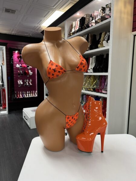 orange micro bikini set with designer-inspired print displayed on mannequin
