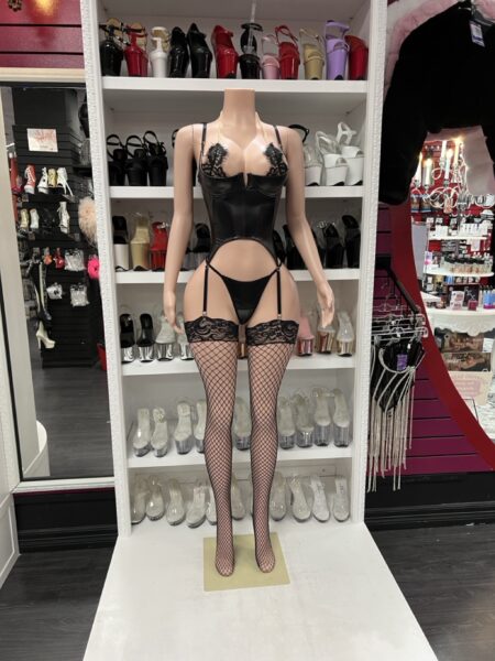 black satin and lace corset set with garter belt, thong, and fishnet stockings on mannequin
