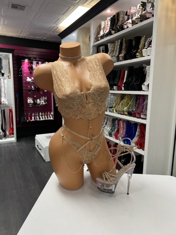 nude lace lingerie set with bralette, thong, and gold body chains on mannequin with gold platform heels