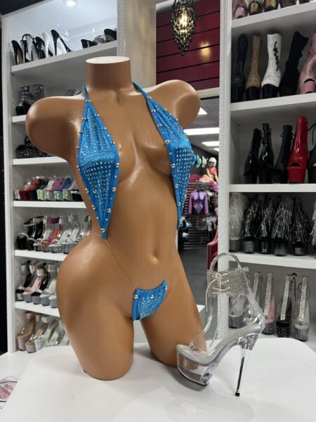 Mannequin wearing a turquoise rhinestone slingshot bikini with matching sparkle heels and lighting that enhances the shimmer