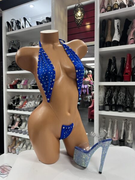 Mannequin modeling a royal blue rhinestone slingshot bikini set with clear rhinestone heels in boutique display