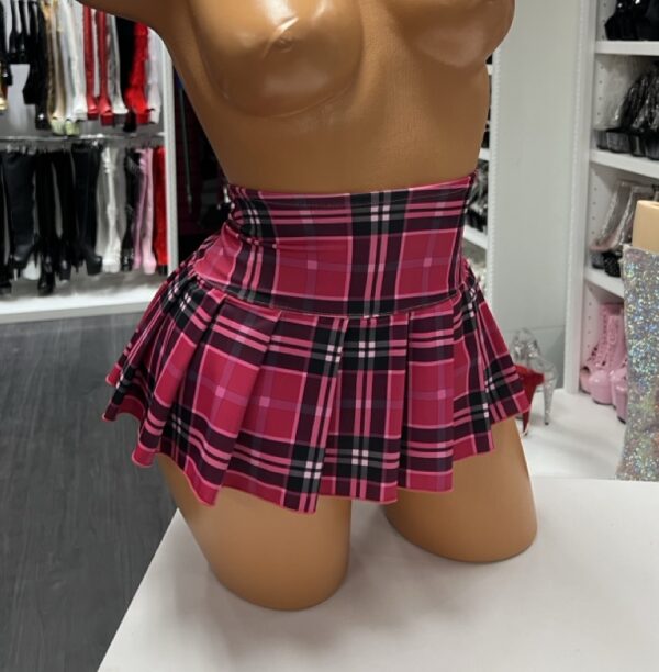 Pink plaid schoolgirl mini skirt with pleated design on model