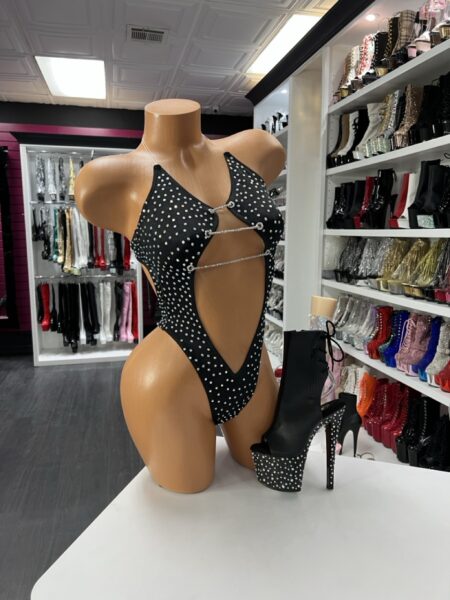 Black Rhinestone Cutout Bodysuit with rhinestone chains and bold cutouts displayed on mannequin with studded platform boots