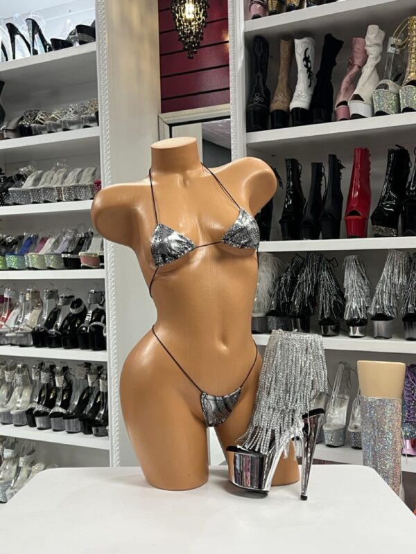 Sleek Style with the Silver Snake Micro Bikini The Silver Snake Micro Bikini is made for bold performers and daring fashion lovers who thrive under the spotlight. This daring two-piece set combines a shimmering silver snakeskin print with a barely-there micro cut that lets you showcase your figure in the most confident way possible. Designed with string ties that keep the top and bottom in place while still leaving maximum skin on display, this bikini is the definition of fearless stagewear. Why Performers Love the Silver Snake Micro Bikini Entertainers, dancers, and show-stoppers know that stage presence starts with an outfit that makes them feel unstoppable. This bikini checks every box: it sparkles under lights, fits like a second skin, and delivers the alluring edge that keeps all eyes locked on you. The micro triangle top gives just enough coverage while enhancing curves, and the ultra-minimal g-string bottoms highlight every move with confidence. Another benefit is its versatility. Whether you’re styling it with thigh-high boots, rhinestone heels, or statement accessories, the bikini pairs effortlessly with bold stage footwear or sparkling jewelry. If you want to make a big impression, this set offers the perfect foundation to layer with fringe pieces, leg garters, or a sheer cover-up. Premium Details in Every Stitch The Silver Snake Micro Bikini isn’t just about the look—it’s also about feel. Made with lightweight, comfortable material, it provides flexibility for dancing, walking, and long hours of wear. Despite its tiny cut, the ties give you adjustable control, so you can secure it exactly how you like. The snakeskin-inspired pattern has an edgy, modern vibe that stands out compared to standard solid-color pieces, making it perfect for performers who want something beyond basic. Shop the Silver Snake Micro Bikini Today Don’t miss your chance to own a piece that turns heads instantly. The Silver Snake Micro Bikini is made for fearless performers, confident trendsetters, and anyone ready to take center stage. Pair it with bold platform heels from our Pleasure Zone shoe collection for a complete look that’s performance-ready. Key Features Micro bikini cut with minimal coverage Silver snakeskin print for eye-catching style Adjustable string ties for custom fit Triangle top and g-string bottom combo Performer-friendly comfort for long wear