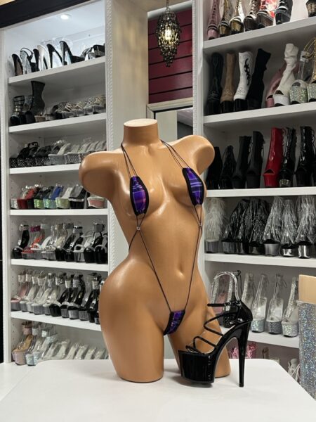 Mannequin wearing purple slingshot micro bikini with ultra-revealing cut and thin straps for stagewear and nightlife fashion