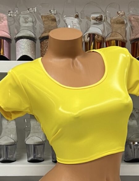 Bright yellow vinyl crop top with short sleeves and scoop neck on model