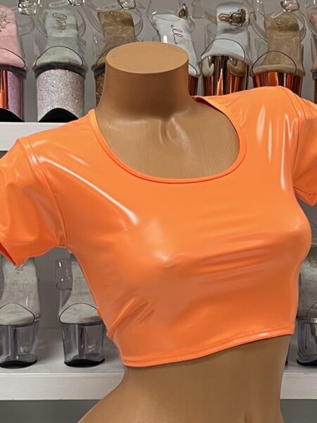 Neon orange vinyl crop top with short sleeves and scoop neck on model