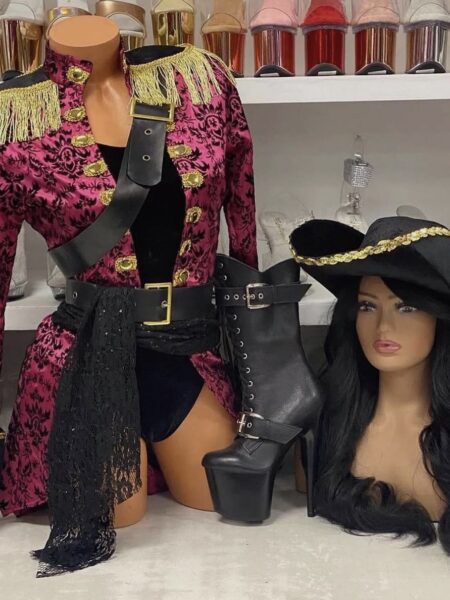 Sexy Swashbuckler Costume with romper, long pirate jacket, sash, belt, and tricorn hat in pink, black, and gold trim.
