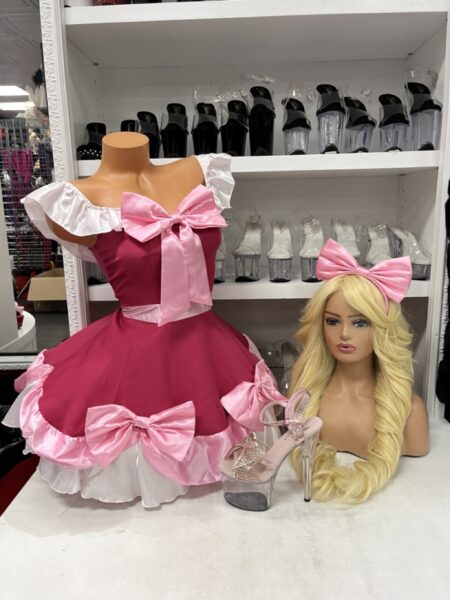 Pink princess costume with satin bows, white ruffled sleeves, flared skirt, and matching pink bow headband.