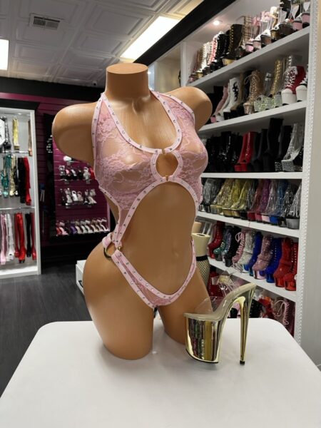 Pink lace cutout bodysuit with rhinestone trim on mannequin
