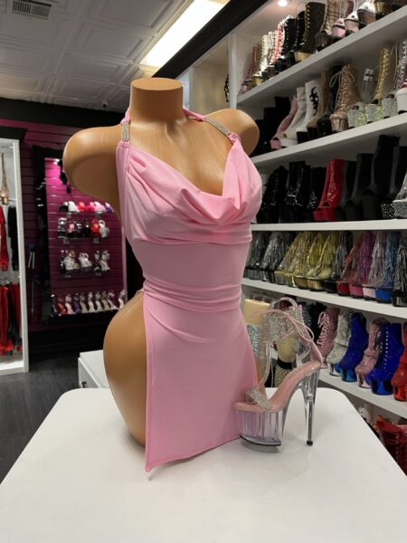Pink mini dress with draped neckline and fitted silhouette displayed on mannequin