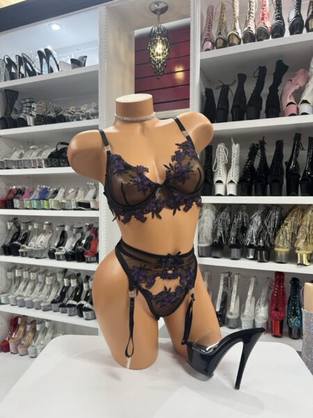 Purple floral lace lingerie set with sheer mesh bra, embroidered details, and garter straps displayed on mannequin