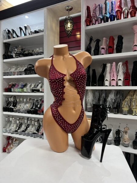 A bold garnet bodysuit featuring rhinestone sparkle and a flattering lace-up front. Designed for confident movement and powerful stage presence.