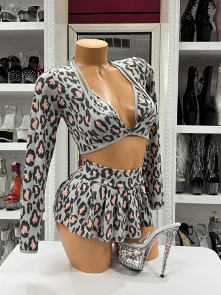 Model wearing blush leopard skirt set with long sleeve crop top and flared mini skirt