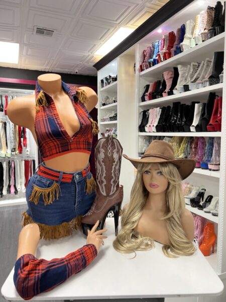 Model wearing plaid fringe cowgirl set with halter top and denim mini skirt