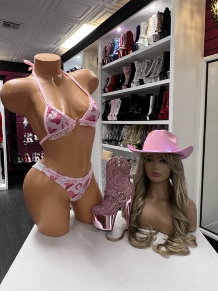 Model wearing pink cow print bikini with lace trim and triangle halter top