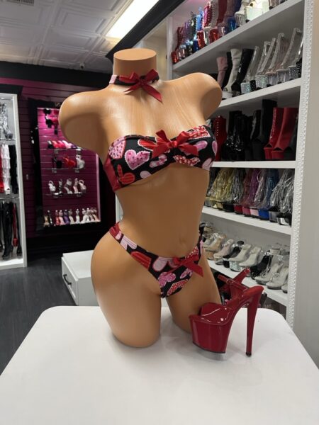 The Love Charm Bandeau Set features a strapless bandeau top, matching thong, and playful heart print design. Soft stretch fabric creates a flattering and comfortable fit.