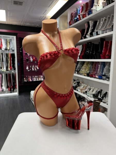 Model wearing scarlet pom pom set with red shimmer fabric and pom pom trim