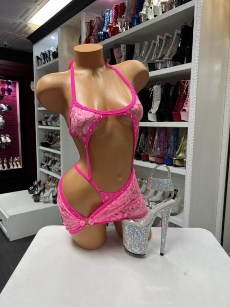 Pink lace micro romper with removable skirt and rhinestone trim detail. Flirty, bold, and designed to stand out.
