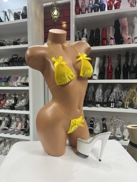 Yellow velvet micro bikini with bow accents and rhinestone details displayed on mannequin