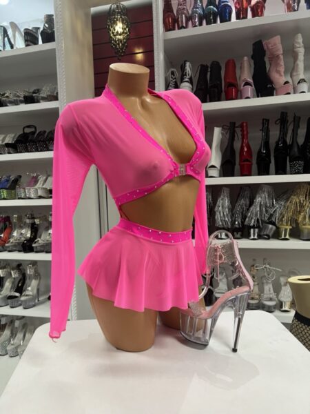 Neon pink long sleeve sling top with matching mini skirt and rhinestone trim displayed on mannequin