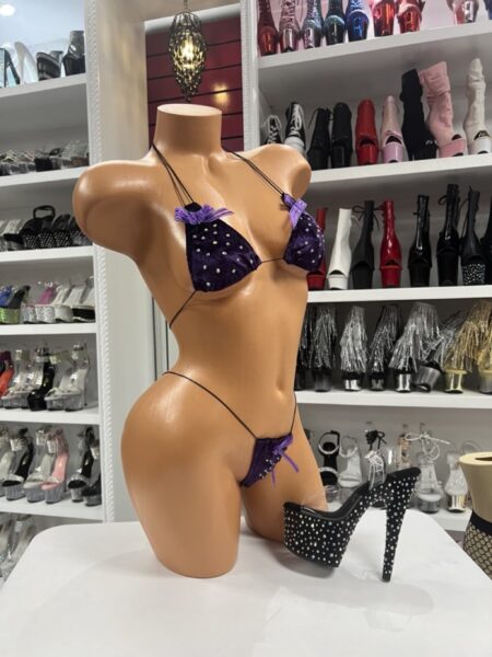Purple velvet micro bikini with bow accents and rhinestone details displayed on mannequin