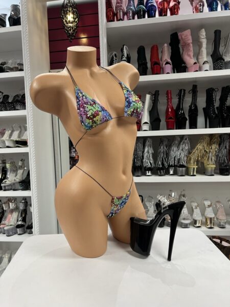 Rainbow kawaii bikini set with triangle top, matching string thong, slim black ties, and colorful character-inspired print.