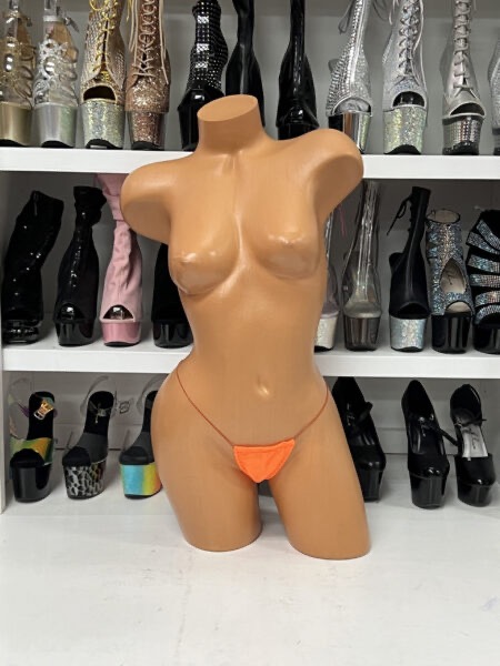 Orange minimal string thong with ultra thin straps and vibrant color on mannequin