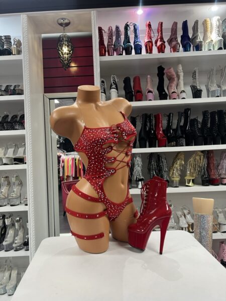 Ruby Rhinestone Lace Romper featuring a lace-up front, sparkling rhinestones, open sides, and attached thigh garters.