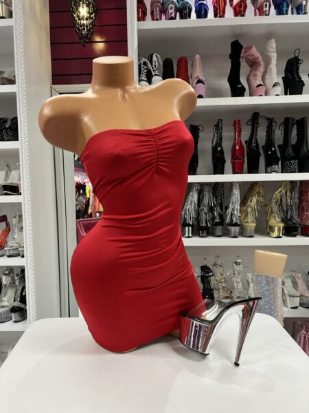 Model wearing Ruby Ruched Tube Dress in vibrant red with a strapless bodycon mini silhouette.