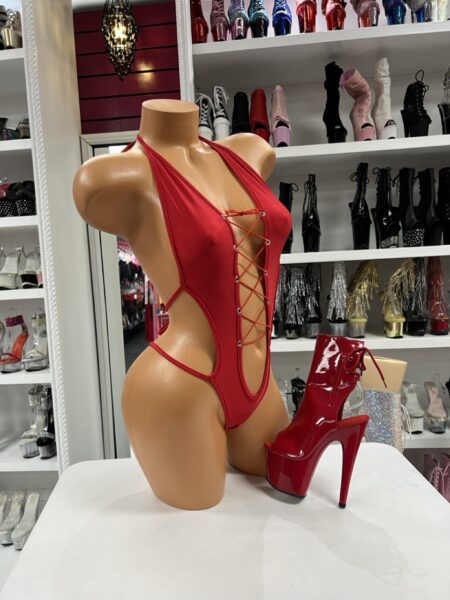 Ruby Lace Up Romper featuring a plunging lace-up front, silver-tone grommets, and dramatic open side styling.