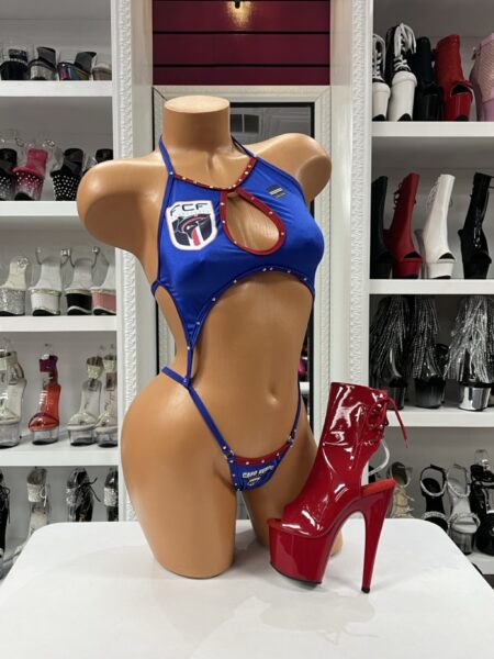 Bold Cabo Verde-inspired soccer monokini featuring blue fabric, red trim, crystal accents, a bust cutout, and a high-cut silhouette.