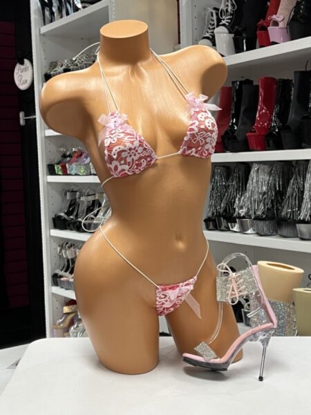 Pink Ruffle String Bikini featuring a floral lace overlay, feminine ruffle trim, satin ribbon bows, adjustable triangle bikini top, matching string bikini bottom, and soft stretch fabric.