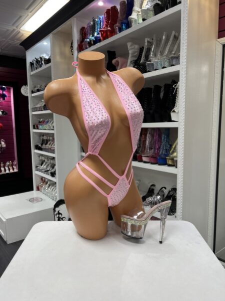 Solid pink string one piece with rhinestone embellishments, plunging neckline, and flattering cutout design.