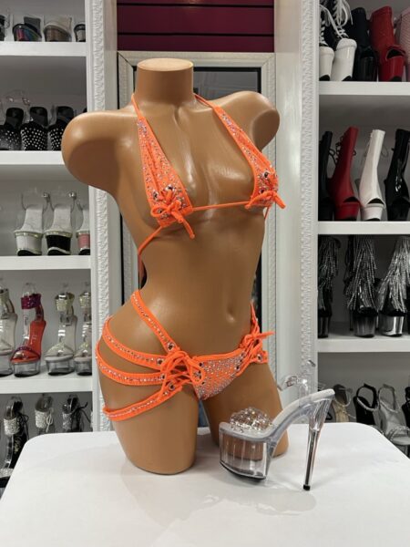 Turn heads in the Neon Orange Knot Bikini, a sparkling two-piece featuring crystal embellishments, lace-up knot details, and dramatic double leg straps. Perfect for festivals, pool parties, vacations, and performance wear.