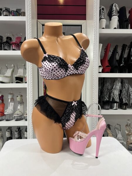Blush pink polka dot bra thong set with an underwire bra, matching thong, black lace trim, sheer mesh, and satin bow accents.
