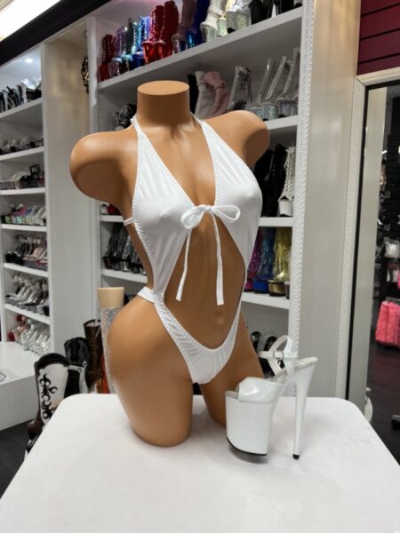 White suspender bra thong with a plunging halter neckline, front bow detail, connected high-cut thong, and open front silhouette.