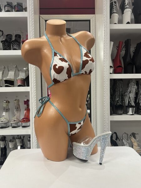 Brown and white cow print bikini featuring a triangle string top, tie-side bottoms, and shimmering turquoise trim.