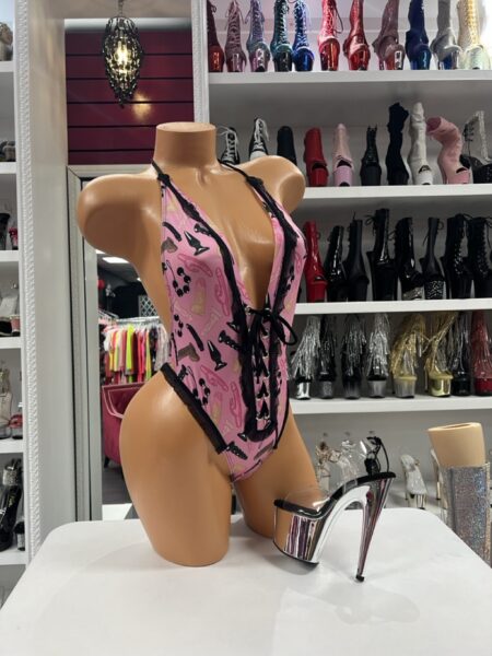 Pink Toy Lace Monokini with toy-inspired print, black lace trim, lace-up corset front, and plunging halter neckline.