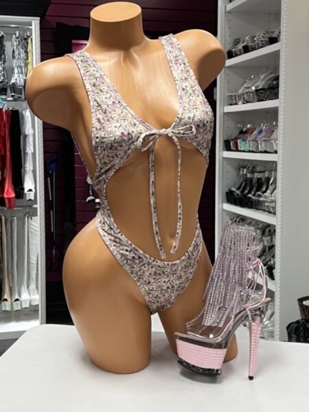 Pink Dollar Bill Monokini featuring an all-over money print, plunging neckline, adjustable front tie, dramatic side cutouts, and a high-cut one-piece silhouette.