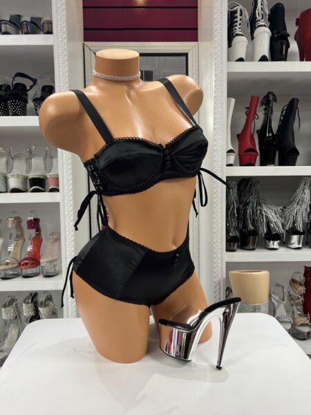 Black satin lingerie set featuring underwire balconette cups, adjustable straps, lace-up side details, and matching high-waisted satin shorts.