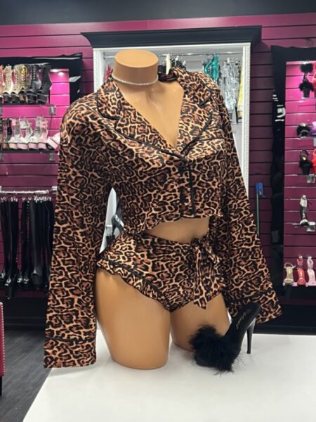 Leopard satin pajama set featuring a cropped button-up long sleeve top, matching tie-waist shorts, black contrast piping, and silky satin fabric.