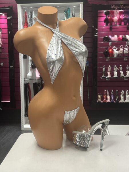 Silver Crystal Slingshot featuring metallic silver stretch fabric, sparkling crystal embellishments, crossed halter neckline, and dramatic open-front design.