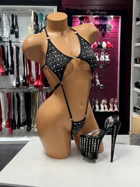 Black O Ring Bodysuit with sparkling rhinestones, polished silver O-ring hardware, adjustable straps, daring cutout design, and a high-cut silhouette displayed on a mannequin.