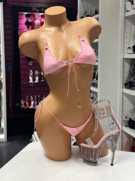 Pink rhinestone string bikini featuring a triangle halter top, adjustable tie-side thong bottom, crystal embellishments, and decorative bead accents.