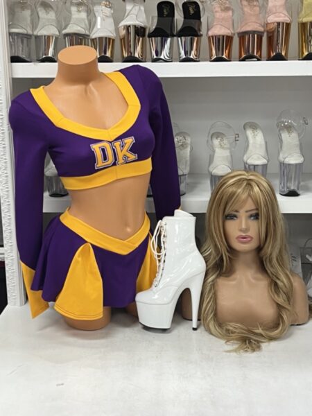 Killer Cheerleader Costume with purple and gold long sleeve crop top, varsity lettering, and matching flared cheer skirt.