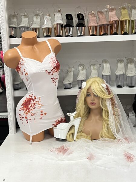 Dead Bride Costume featuring a white blood splatter mini dress with lace neckline, blonde bridal wig, bloodstained veil, and white platform heel