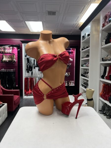 Ruby Crystal Cutout Set featuring a ruby red strapless bandeau top with rhinestone accents, a center ring, and a matching asymmetrical mini skirt with an open hip cutout.
