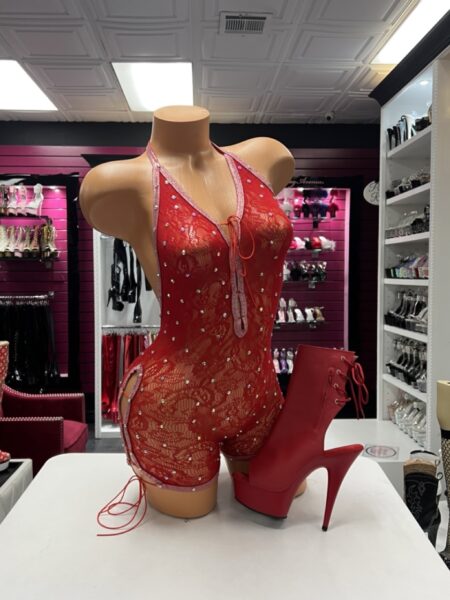 Red lace romper featuring sheer floral lace, sparkling rhinestones, a halter neckline, low-back design, and adjustable side lacing.